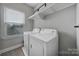 Practical laundry room with a washer, dryer, a storage shelf, and a window providing natural light at 8702 Aspinwall Dr, Charlotte, NC 28216