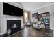 Cozy living room featuring a fireplace, hardwood floors, comfortable seating, and stylish decor at 8702 Aspinwall Dr, Charlotte, NC 28216