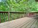The wooden deck overlooks a verdant forest of lush green foliage and stands ready for peaceful outdoor enjoyment at 9214 Arbourgate Meadows Ln, Charlotte, NC 28277