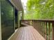 An expansive wooden deck looks out onto lush greenery through a large sliding glass door from the home's interior at 9214 Arbourgate Meadows Ln, Charlotte, NC 28277