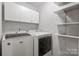 Efficient laundry room equipped with modern washer/dryer and cabinet storage; perfect for streamlined chores at 9214 Arbourgate Meadows Ln, Charlotte, NC 28277