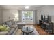 Comfortable living room featuring a plush gray sectional and bright windows at 9214 Arbourgate Meadows Ln, Charlotte, NC 28277