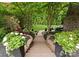 Beautifully landscaped backyard with stone steps leading to a manicured lawn and vibrant garden beds at 1021 Westbury Dr, Matthews, NC 28104