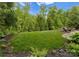Lush green lawn surrounded by mature trees, creating a private and serene outdoor space at 1021 Westbury Dr, Matthews, NC 28104