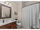 Cozy bathroom with a single sink vanity, a framed mirror, and a shower with a patterned shower curtain at 1021 Westbury Dr, Matthews, NC 28104
