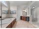 Primary bath featuring a jetted tub, dual sink vanity, tiled floor and artwork at 1021 Westbury Dr, Matthews, NC 28104