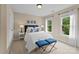 Inviting bedroom offers natural light with two windows, two blue ottomans and a queen bed at 1021 Westbury Dr, Matthews, NC 28104