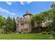 Expansive brick home with multiple windows, a well-maintained lawn, and landscaped garden at 1021 Westbury Dr, Matthews, NC 28104