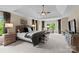 Large primary bedroom with tray ceiling, sitting area, and green views at 1021 Westbury Dr, Matthews, NC 28104