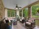 Relaxing sunroom with neutral-colored furniture, ceiling fan, and large windows overlooking the wooded backyard at 1021 Westbury Dr, Matthews, NC 28104