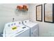 Bright laundry room features a washer and dryer with storage shelves and art at 1033 20Th Avenue Se Loop, Hickory, NC 28602