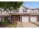 Charming two-story townhome with brick and white siding, featuring a one-car garage and inviting front entrance at 104 Clydesdale Ct, Matthews, NC 28104