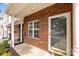Inviting front porch with brick facade, white trim, and a glass-paneled front door at 104 Clydesdale Ct, Matthews, NC 28104