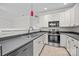 Modern kitchen with white cabinets, stainless steel appliances, and sleek gray countertops at 104 Clydesdale Ct, Matthews, NC 28104