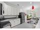 Well-lit kitchen featuring stainless steel appliances, white cabinetry, and gray countertops at 104 Clydesdale Ct, Matthews, NC 28104