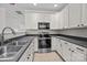 Modern kitchen with white cabinets, stainless steel appliances, and sleek gray countertops at 104 Clydesdale Ct, Matthews, NC 28104