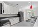 Well-lit kitchen featuring stainless steel appliances, white cabinetry, and gray countertops at 104 Clydesdale Ct, Matthews, NC 28104