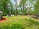 Grassy backyard with mature trees, sheds, and landscaped areas, providing a serene and spacious outdoor environment at 105 Strickland Ln, Bessemer City, NC 28016