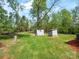 Large backyard featuring lush greenery and two storage sheds, offering ample space for outdoor activities at 105 Strickland Ln, Bessemer City, NC 28016