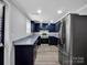 Modern eat-in kitchen with navy cabinets, granite countertops, stainless steel appliances and wood look floors at 105 Strickland Ln, Bessemer City, NC 28016