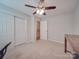 Carpeted bedroom with fan and double closet, plus natural light from window at 1052 Churchill Downs Ct # I, Charlotte, NC 28211