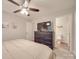 Comfortable bedroom with ceiling fan, adjoining bathroom, and modern dresser at 1052 Churchill Downs Ct # I, Charlotte, NC 28211