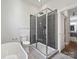 Modern bathroom featuring a glass-enclosed shower with gray subway tile, a sleek tub, and stylish fixtures at 1054 Kenilworth Ave, Charlotte, NC 28204