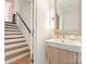 Half bathroom with modern vanity, mirror, and lighting next to the hardwood staircase at 1054 Kenilworth Ave, Charlotte, NC 28204