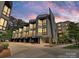 Modern townhome row showcasing unique architectural design and convenient attached garages, against a colorful sky at 1054 Kenilworth Ave, Charlotte, NC 28204