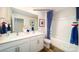 Bright bathroom with double sinks, white cabinets and a tub with blue shower curtain at 1064 20Th Avenue Se Loop, Hickory, NC 28602