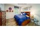 Comfortable bedroom with a bed, wood floors, large window and basketball decor at 1064 20Th Avenue Se Loop, Hickory, NC 28602