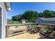 Relaxing backyard deck offers seating, greenery, and backyard access on a sunny day at 109 Hunter Ct, Oakboro, NC 28129