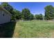 Large backyard with green lawn and trees. A perfect outdoor space for activities at 109 Hunter Ct, Oakboro, NC 28129