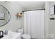 Stylish bathroom featuring modern fixtures, a round mirror, and a shower with a white curtain at 109 Hunter Ct, Oakboro, NC 28129