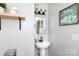 Charming powder room with pedestal sink, decorative mirror, and modern lighting fixtures at 109 Hunter Ct, Oakboro, NC 28129