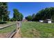 View of a charming property with a wooden fence and green lawn, evoking a serene, countryside ambiance at 109 Hunter Ct, Oakboro, NC 28129