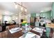 Eat-in kitchen features stainless appliances, green cabinetry, and a view to the Gathering room beyond an arched doorway at 109 Hunter Ct, Oakboro, NC 28129