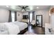Comfortable main bedroom features a ceiling fan, hardwood floors, and a sitting area with a floor-length mirror at 109 Hunter Ct, Oakboro, NC 28129