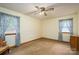 Bright bedroom features two windows with curtains, carpeted floors, and ceiling fan at 115 Patterson Rd, Kings Mountain, NC 28086