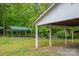 Lush greenery surrounds an additional open carport, adding practical covered space to the expansive backyard and garden at 115 Patterson Rd, Kings Mountain, NC 28086