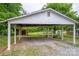 Open carport with a gravel floor, providing covered parking and storage space at 115 Patterson Rd, Kings Mountain, NC 28086