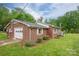 Exterior shot of a brick home with an attached garage, complemented by a well-kept lawn and lush greenery at 115 Patterson Rd, Kings Mountain, NC 28086