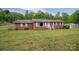 Inviting brick home with white shutters and a well-maintained lawn, surrounded by a backdrop of lush trees at 115 Patterson Rd, Kings Mountain, NC 28086