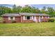 Charming brick home with white shutters and a well-manicured lawn in a serene, wooded setting at 115 Patterson Rd, Kings Mountain, NC 28086