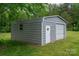 Garage featuring both a roll-up door and a side entrance provides flexible storage and access in a lush green setting at 115 Patterson Rd, Kings Mountain, NC 28086