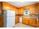 Cozy kitchen with wood cabinets, white appliances, and tile flooring creates a classic, functional space at 115 Patterson Rd, Kings Mountain, NC 28086