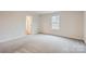 Spacious bedroom with neutral carpet, a window, and a door leading to another room at 118 Dorian Pl, Troutman, NC 28166