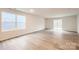 Bright living room featuring hardwood floors, large windows, and a sliding glass door to the backyard at 118 Dorian Pl, Troutman, NC 28166