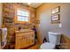 Unique bathroom design with stone walls and a custom wood vanity under natural lighting at 1307 Tiffany Ln, Shelby, NC 28152