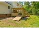 A wooden back porch with a ramp and stairs overlooks the yard and adjacent wooded area at 1338 Pell Dr, Lincolnton, NC 28092